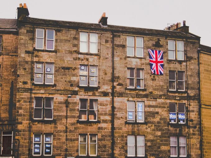 Bloc de pisos de Leith amb posters del Sí i del No i una bandera britànica. © Brian McNeil